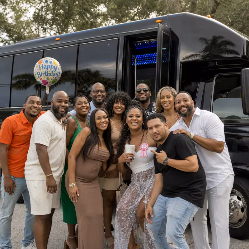 Group boarding a white charter bus for Birthday Transportation transportation in Detroit