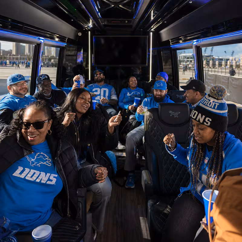 Group boarding a white charter bus for Sporting Event Transportation transportation in Detroit